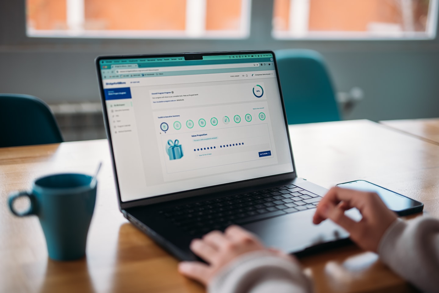 Hände tippen auf einem Laptop mit einem Business-Software-Dashboard.